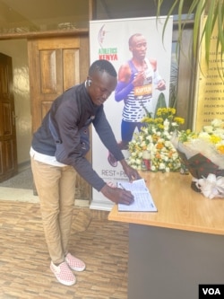 Brian Chebii, a resident of Elgeyo-Marakwet County, Kenya, signs a condolence book on Feb. 21, 2024, in Nairobi for marathon world record-holder Kelvin Kiptum, who was killed in a car crash. (Mariama Diallo/VOA)