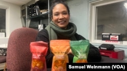 Patrice Cunningham, founder and CEO of Tae-Gu Kimchi, poses in her Washington office with three bags of the kimchi she makes and distributes with her mother, Jan. 24, 2024.