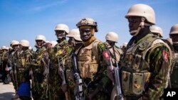 Members of a police force from Kenya stand on the tarmac of Toussaint Louverture International Airport after landing in Port-au-Prince, Haiti, June 25, 2024. 