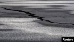 A road is damaged in the village of Grindavik, which was evacuated due to volcanic activity, in Iceland, Nov. 14, 2023. 
