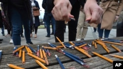 Journalists breaks pencils during a protest outside the parliament during the session about controversial amendments to the criminal code that would make defamation a crime punishable with stiff fines, in the Bosnian town of Banja Luka, March 14, 2023. 
