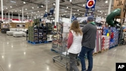 FILE - Shoppers pass displays of goods in a Costco warehouse Sheridan, Colorado, Feb. 25, 2024. With less than four months to go before Election Day, U.S. voters are prioritizing the health of their wallets and pocketbooks.