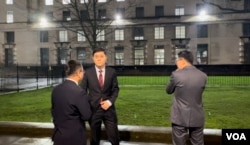 一群香港示威者在伦敦抗议香港经济质易办事处农历新年酒会，一度令中国驻英国大使馆公使杨晓光（图中）一行人在外面等候未有入场。 美国之音记者询问他们是否大使馆的人员后，他们不发一言急步走入伦敦市中心国宴厅会场 (美国之音/郑乐捷)