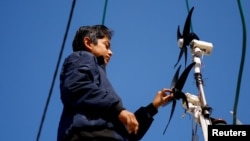 Displaced Palestinian teenager Hussam Al-Attar works on wind turbines, that he uses to light up his shelter during power cut, at a tent camp in Rafah, in the southern Gaza Strip, February 6, 2024. (REUTERS/Ibraheem Abu Mustafa)