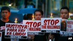 FILE - Protesters hold placards in a candlelit protest against the extrajudicial killings in President Rodrigo Duterte's "War on Drugs" campaign in suburban Quezon city, northeast of Manila, Philippines, Oct. 8, 2016.