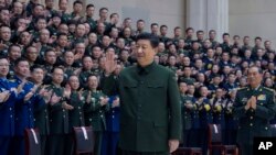 In this photo released by Xinhua News Agency, Chinese President Xi Jinping waves as he meets with military officers stationed in north China's Tianjin Municipality ahead of the Chinese Lunar New Year, Feb. 2, 2024.