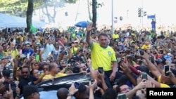 Mantan Presiden Brazil Jair Bolsonaro menyapa para pendukungnya yang hadir dalam aksi unjur rasa di Copacabana, Rio de Janeiro, pada 21 April 2024. (Foto: Reuters/Pilar Olivares)