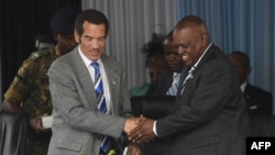 ARCHIVES - Le président sortant du Botswana, Ian Khama (à g.), serre la main de son vice-président, Mokgweetsi Masisi, le 27 mars 2018, avant de lui remettre officiellement le pouvoir le 1er avril 2018.