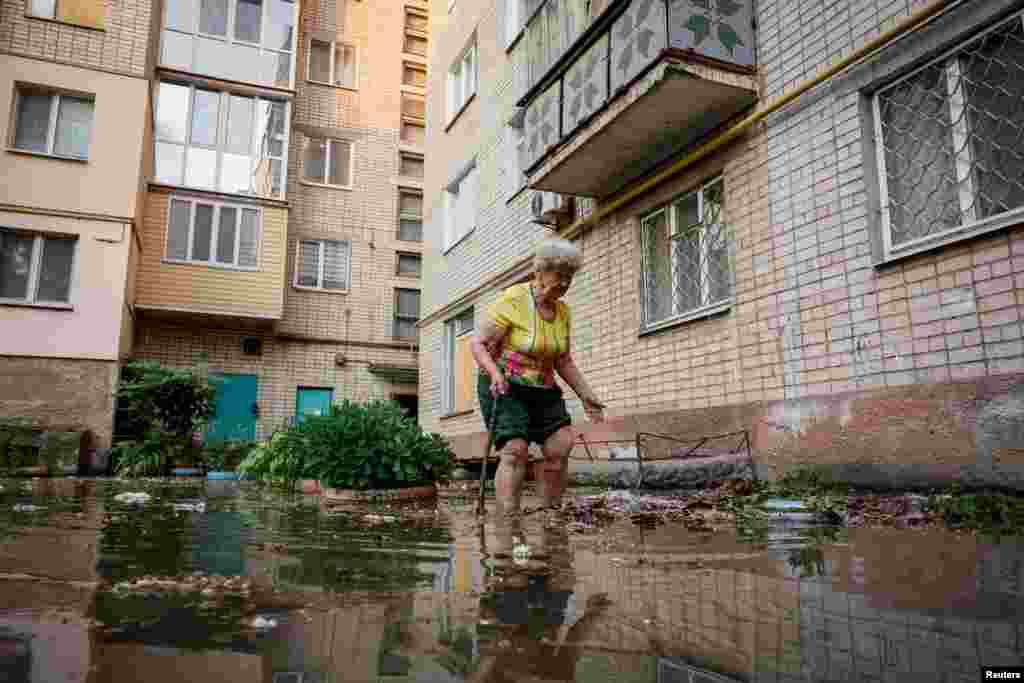Oleksandra walks around her house on a flooded street, after the Nova Kakhovka dam breached, in Kherson, Ukraine, June 6, 2023.