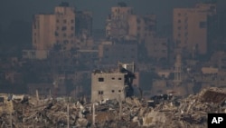 Bangunan-bangunan yang hancur tampak di Jalur Gaza, terlihat dari Israel selatan pada 20 November 2023. (AP Photo/Leo Correa)