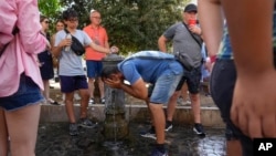 A man refreshes himself at a fountain in Rome, Italy, July 17, 2023. Tourist flock to the eternal city while scorching temperatures grip central Italy with Rome at the top of the red alert list as one of the hottest cities in the country.