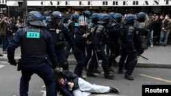 French riot police apprehend a protester amid clashes during a demonstration as part of nationwide strikes and protests against French government's pension reform, in Paris, March 23, 2023.