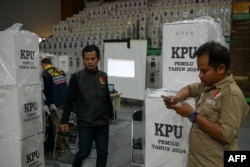 Pejabat Komisi Pemilihan Umum (KPU) dan saksi partai melakukan rekapitulasi hasil tabulasi di tingkat kecamatan di Jakarta pada 16 Februari 2024. (BAY ISMOYO / AFP)