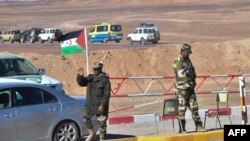 Un drapeau du Sahara occidental flotte à un poste de contrôle tenu par des membres des forces de sécurité sahraouies à l'extérieur du camp de réfugiés de Dakhla, 14 janvier 2023. AFP / Ryad Kramdi