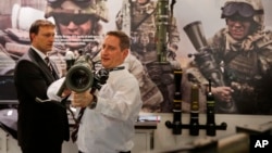 FILE - An exhibitor of SAAB, a Swedish defense company, shows the 85MM Carl-Gustaf, a portable artillery system during the 8th International Land and Naval Defense system exhibition, in New Delhi, India, Feb. 6, 2014.