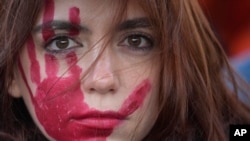 A woman attends a demonstration on the occasion of International Day for the Elimination of Violence against Women, in Milan, Italy, Nov.25, 2023. 