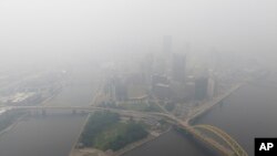 FILE - Haze from Canadian wildfires blankets the downtown Pittsburgh skyline as seen from Elliott, Pa., June 28, 2023.