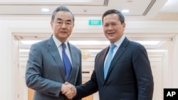 រដ្ឋមន្ត្រីការបរទេសចិនលោក Wang Yi និងនាយករដ្ឋមន្ត្រីកម្ពុជាលោក ហ៊ុន ម៉ាណែត ចាប់ដៃស្វាគមន៍គ្នា នៅវិមានសន្តិភាព រាជធានីភ្នំពេញ នាថ្ងៃទី២២ ខែមេសា ឆ្នាំ២០២៤។ (AKP via AP)