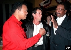 FILE - Former heavyweight boxing champion Muhammad Ali, left, joins Sylvester Stallone, center, and Stallone's "Rocky" co-star, Carl Weathers, right, to mark the 20th anniversary of the movie "Rocky" during a party in New York in 1996.