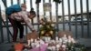 A girl lights candle during a vigil for the victims of a fire at an immigration detention center that killed dozens in Ciudad Juarez, Mexico, March 28, 2023. 