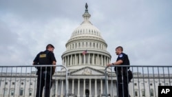FILE - U.S. Capitol Police officers stand at the Capitol in Washington, July 24, 2024. Two men from Europe have been charged in a plot to call in dozens of bogus emergencies from December 2020 through January 2024, including a threat to set off explosives at the U.S. Capitol. 