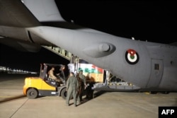 This handout image made available by the Jordanian Armed Forces Media office on Nov. 6, 2023, shows humanitarian aid being loaded into a Jordanian military cargo plane. (Photo by Jordanian Armed Forces / AFP)