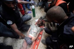 Palestinians rescue a wounded girl from under the rubble of a destroyed building following an Israeli airstrike in Khan Younis refugee camp, southern Gaza Strip, Nov. 7, 2023.