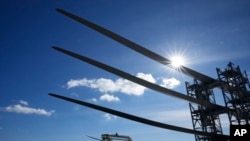 A generator and its blades, bottom, are tugged at sea leaving State Pier in New London, Conn., Dec. 4, 2023, heading to South Fork Wind farm.