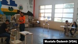 Venezuela'da dün yapılan halk oylamasında bir seçmen oy kullanırken