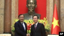 ប្រធានាធិបតី​វៀតណាម​លោក Vo Van Thuong (ស្តាំ) ចាប់ដៃ​ជាមួយ​រដ្ឋមន្ត្រី​ក្រសួងការបរទេស​កម្ពុជាលោក​ប្រាក់ សុខុន(ឆ្វេង)​ក្នុង​ទីក្រុង​ហាណូយ​ប្រទេស​វៀតណាម​កាលពី​ថ្ងៃទី​២១ មីនា ឆ្នាំ២០២៣។(AP Photo/Hau Dinh)