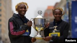 Les Kenyans Evans Chebet, à droite, et Hellen Obiri posent après leurs victoires au Marathon de Boston, États-Unis, le 17 avril 2023.