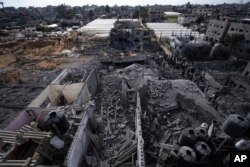 Palestinians inspect the damage to residential buildings where two Israeli hostages were reportedly held before being rescued during an operation by Israeli security forces in Rafah, southern Gaza Strip, Feb. 12, 2024.