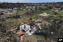 Debris is strewn around tornado damaged homes, Sunday, March 26, 2023, in Rolling Fork, Miss. (AP Photo/Julio Cortez, File)