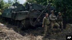 Ukrainian soldiers stands near an armored recovery vehicle on the front line in the Zaporizhzhia region, Ukraine, July 1, 2023.