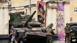 Arxiv fotosu - Vaqner Qrupunun üzvləri Rusiyanın Rostov şəhərinin küçələrindən birində tankın qarşısındakı ərazini qoruyur, 24 iyun, 2023.