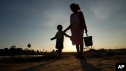 រូបឯកសារ៖ ស្ត្រីមានផ្ទៃពោះនិងកូនដើរកាត់ក្នុងភូមិមួយ នៅជាយរាជធានីភ្នំពេញ កាលពីថ្ងៃទី៤ ខែមករា ឆ្នាំ២០១៨។