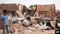A man walks by a house hit in recent fighting in Khartoum, Sudan, April 25, 2023.