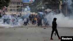 A police officer walks after using tear gas to disperse protesters during a demonstration over police killings of people protesting against Kenya's proposed finance bill 2024/2025, in Nairobi, June 27, 2024. 