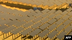 FILE - Workers inspect solar panels at the fishing-solar complementary photovoltaic power generation base in Taizhou, in China's eastern Jiangsu province, July 12, 2023.