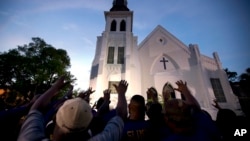 Members of the Omega Psi Phi Fraternity lead people in prayer outside the Emanuel African Methodist Episcopal Church after a memorial for nine people who were shot and killed in Charleston, S.C., Friday, June 19, 2015. (AP Photo/Stephen B. Morton, File)