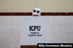 Seorang perempuan memberikan suaranya di TPS saat pemilihan umum, di Surakarta, Jawa Tengah, 14 Februari 2024. (Foto: REUTERS/Willy Kurniawan)