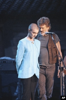 FILE - Kris Kristofferson comforts Sinead O'Connor after she was booed during the Bob Dylan anniversary concert in New York, Oct. 17, 1992. It was her first live event since she ripped a picture of Pope John Paul II on NBC's "Saturday Night Live."
