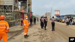 Police officers and workers stand near the site where a furnace explosion occurred at PT Indonesia Tsingshan Stainless Steel smelting plant in Morowali, Central Sulawesi, Indonesia, Dec. 24, 2023. 