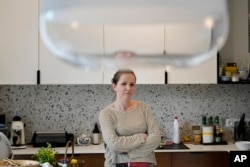 Magda Kozak, a mother of three, stands in her home in Warsaw, Poland, April 5, 2024. She's not pleased about the government's decision to order limits on the amount of homework teachers can assign students. "It helps stay on top of what the child has really learned," she said.