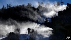 Man-made snow is blown from snowmaking equipment near the summit of Pleasant Mountain ski resort, Dec. 21, 2023, in Bridgton, Maine.