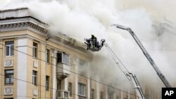 In this photo provided by the Dnipropetrovsk Regional Military Administration, rescuers work on the scene of a building damaged after a Russian attack in Dnipro, Ukraine, April 19, 2024.