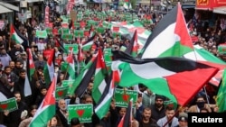 FILE - Demonstrators carry flags and banners during a protest in support of Palestinians in Gaza, amid the ongoing conflict between Israel and the Palestinian Islamist group Hamas, in Amman, Jordan, March 22, 2024.