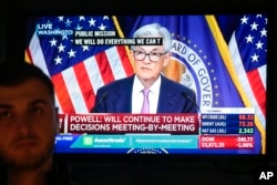 A television displays a news conference with Federal Reserve chairman Jerome Powell as traders work on the floor at the New York Stock Exchange in New York, June 14, 2023.