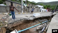 Warga setempat memeriksa saluran air yang rusak di Shooters Hill, Jamaika, setelah Badai Beryl melanda kawasan itu, Kamis 4 Juli 2024.