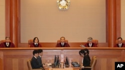 South Korea's Constitutional Court Chief Justice Yoo Nam-seok, top center, and other judges sit before the judgment at the Constitutional Court in Seoul, South Korea, Tuesday, July 25, 2023. (Yonhap via AP)